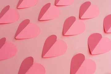 Paper cut of pink hearts on pink background. Valentine's Day background