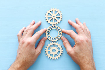 hand placing a cogwheel in set of gears mechanism