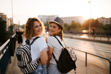 Close-up image of two female best friends walking in the city in the summer.