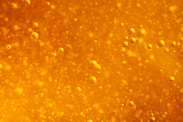 Abstract macro honey bubbles closeup in bright amber color. The texture of the honey. Healthy food concept. Diet. Selective focus.