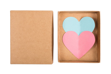Above view on two paper hearts in cardboard box isolated on white background. Pink and blue hearts cut from paper in box