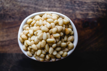 Pine Nuts on Dark Wooden Table. Closeup, horizontal. Raw Healthy Food