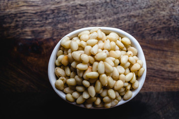 Pine Nuts on Dark Wooden Table. Closeup, horizontal. Raw Healthy Food