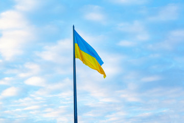 Ukrainian flag flies against sky.