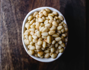 Pine Nuts on Dark Wooden Table. Closeup, horizontal. Raw Healthy Food
