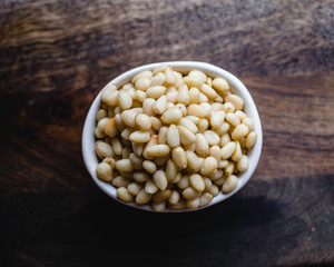 Pine Nuts on Dark Wooden Table. Closeup, horizontal. Raw Healthy Food