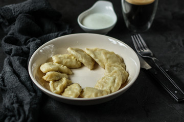 dumplings in a white plate (stuffing dough, different fillings). food background. dark background. top