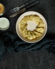 dumplings in a white plate (stuffing dough, different fillings). food background. dark background. top