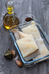 raw cod fish in water in glass dish