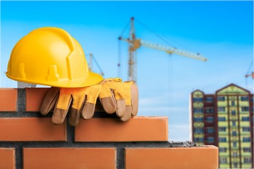 Yellow helmet with equipment on construction background