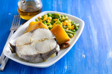 boiled fish with vegetables on white dish