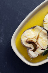 boiled fish with olive oil and rosemary in dish