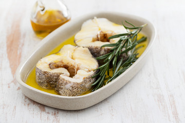 boiled fish with rosemary and olive oil in dish