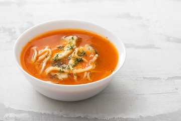 fish soup in the white bowl on ceramic background