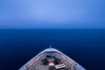 POV shot of bow of a ship sailing into a fog bank in pre dawn hours