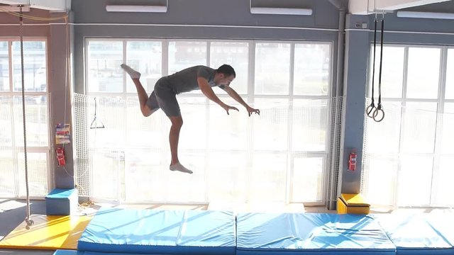 Fitness man jumping on small trampolines,exercise on rebounder. slow motion