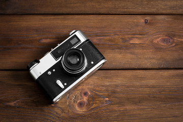 Old camera on a wooden background