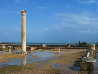 Fototapeta premium Carthage, Tunisia - April 12, 2018: Ruins of Bathhouse of Carthage and view to Mediterranean sea, Tunisia. UNESCO world heritage.