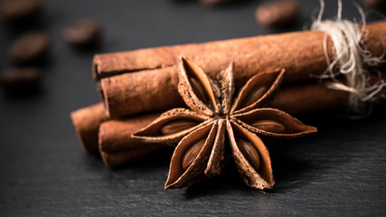 cinnamon and anise and coffee beans on a black background