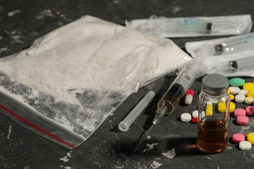 Various addictive drugs. cocaine, heroin and pills on a black table. The concept of drug addiction.