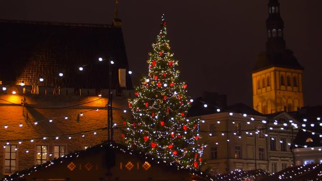 holidays and celebration concept - christmas tree and market at old town hall square in evening tallinn