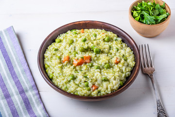 Traditional Italian vegetarian risotto with peas in rustic style