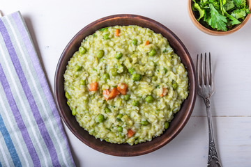 Traditional Italian vegetarian risotto with peas in rustic style