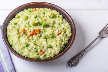 Traditional Italian vegetarian risotto with peas in rustic style