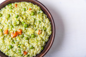 Traditional Italian vegetarian risotto with peas in rustic style, copy space for recipe