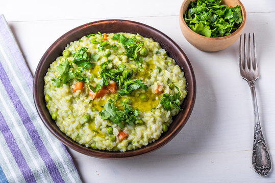 Traditional Italian vegetarian risotto with peas in rustic style