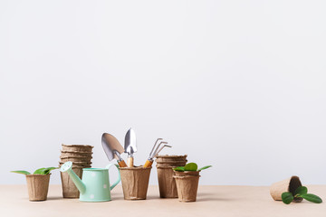 Gardening tools, paper pots, watering can on craft paper with copy space. concept of planting