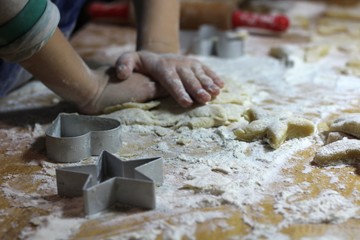 Cooking on kitchen. Having fun together while making cakes and cookies.  Child rolling out dough for christmas cookies.