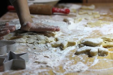 Cooking on kitchen. Having fun together while making cakes and cookies.  Child rolling out dough for christmas cookies.