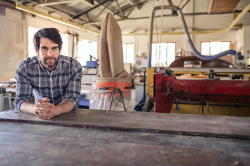 Fototapeta na wymiar Woodworker thinking of new desings in his workshop