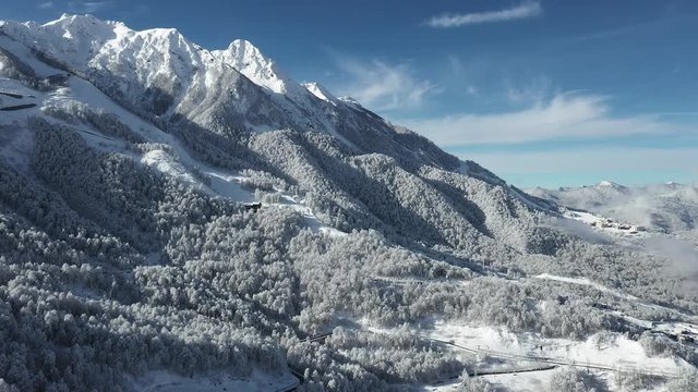 Beautiful view of the mountains in the snow. Nature, mountains, snow, holidays, weekends, skiing, freeride, snowboarding, cable car, clear sky. Aerial photography with copter
