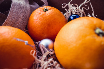 Fresh oranges in a box with New Year's toys
