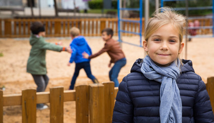 Joyful little girl on the background of playing children