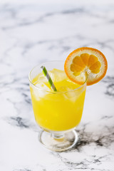 Tasty Orange Juice in Glass With Ice Cube Blue and White Background Fresh Oranges Vertical