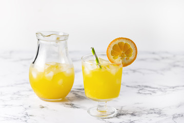 Tasty Orange Juice in Glass With Ice Cube Blue and White Background Fresh Oranges Horizontal