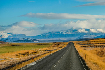 Long Road in iceland with snow mounrtain background