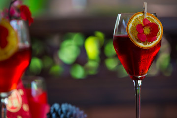 Red cocktail decorated with orange slice. Refreshing holiday aperitif for Christmas party.