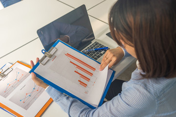Young Asian businesswoman reading financial reports on the table in the business meeting room