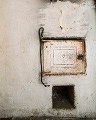 Cast iron door and poker for coal on a traditional, old Russian stove. Close-up.