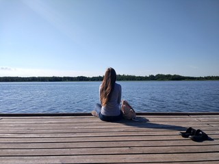 young woman sitting on a pier