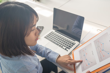 Asian office woman reading financial reports in office