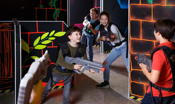 Modern kids aiming laser guns at other players