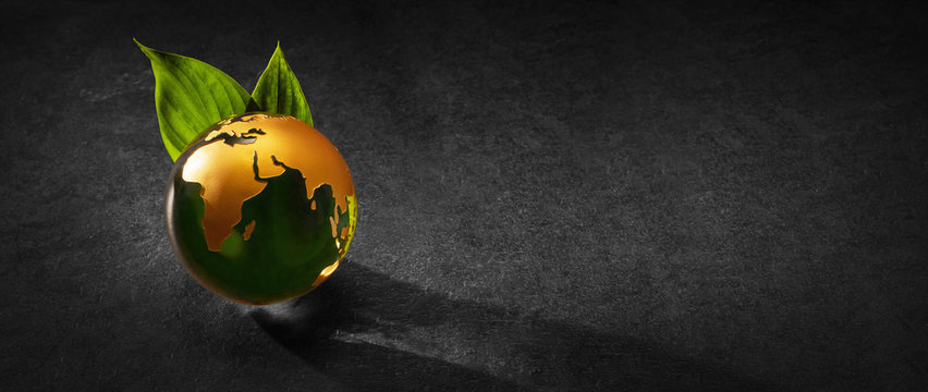 Planet Earth with Green Leaves on a Dark Background. Ecological Concept