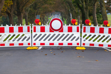 Closed Forbidden Road / Red and white colored street barrier on closed avenue road at countryside, grey asphalt copy space background - 244550028