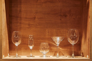 Different types of empty glasses on a wooden background