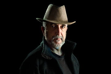 Portrait of adult man with hat, isolated on black background